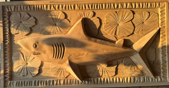 Hand-carved shark and hibiscus wall panel in ash, raw carving before finishing