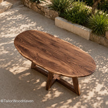 Oval outdoor coffee table made of solid wood with a smooth surface and balanced design