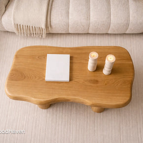 Wooden coffee table with candles and a book on a light-colored floor, branded 'Tailor Wood Haven'.
