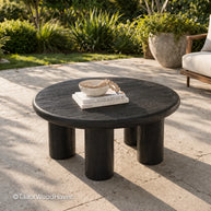 Round black outdoor coffee table made of solid wood with a smooth surface and modern design