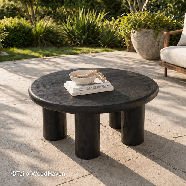 Round black outdoor coffee table made of solid wood with a smooth surface and modern design