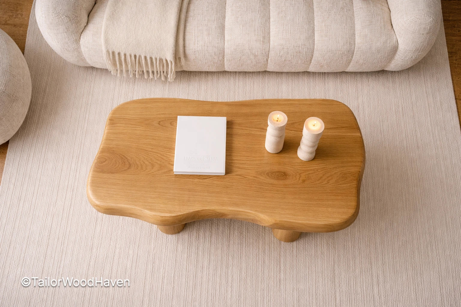 Wooden coffee table with candles and a book on a light-colored floor, branded 'Tailor Wood Haven'.