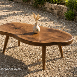 Oval outdoor coffee table made of solid wood with a smooth surface and curved design