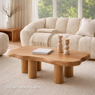 Small oval wooden coffee table in a living room with a beige sofa and decor items.