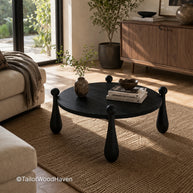 Black round coffee table with smooth surface and solid wood construction