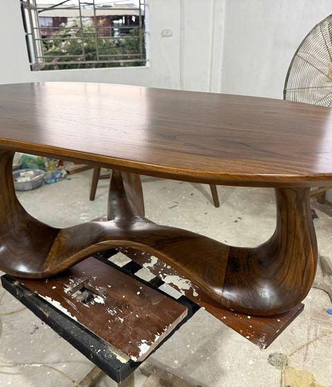 Walnut oval coffee table with a sculpted base