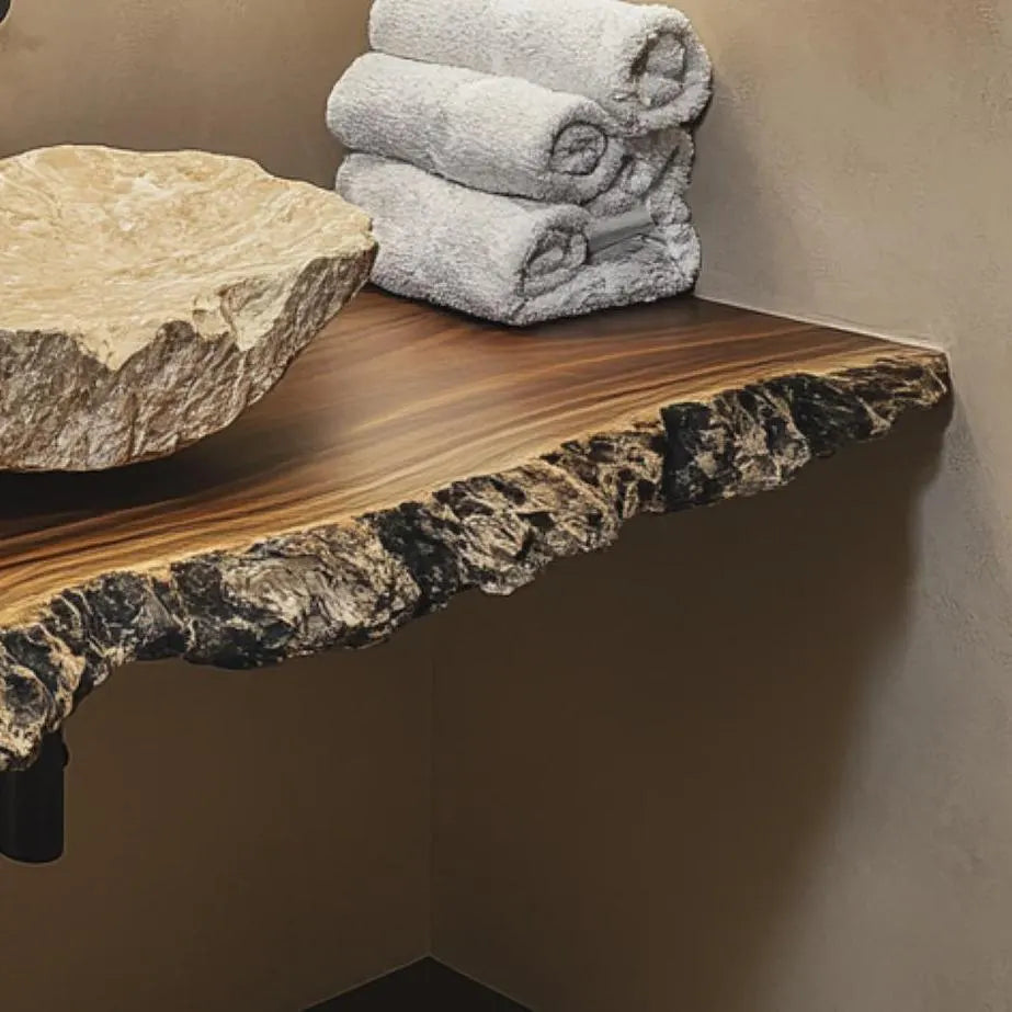 Close-up of a rustic live edge vanity top with a stone sink and rolled towels